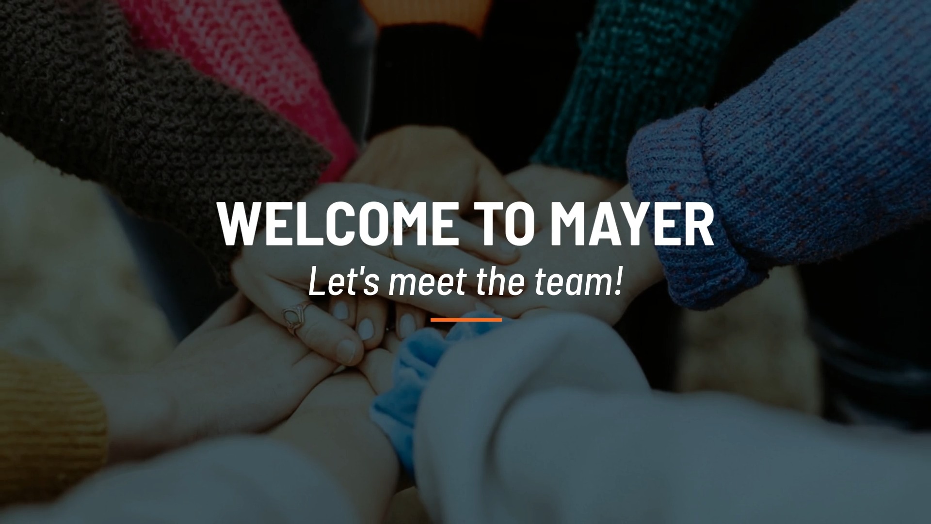 A group of individuals participating in a team-building hand stack with the welcoming text "Welcome to Mayer, let's meet the team!" created using Biteable video maker.