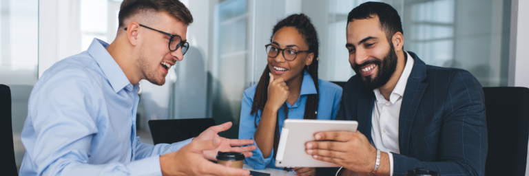 Three professionals in a meeting, discussing over a digital tablet with positive expressions, using Biteable video maker.